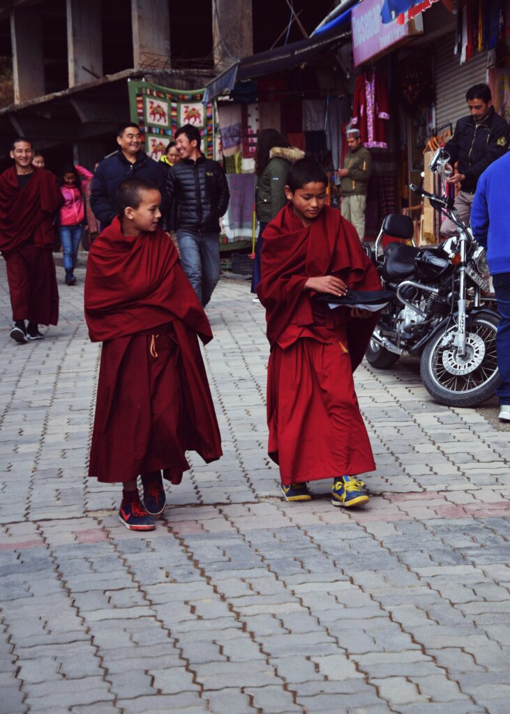 Two Buddhist lamas walking on a street in McLeod Ganj towards Dalai Lama Temple in Dharamshala, Himachal Pradesh.