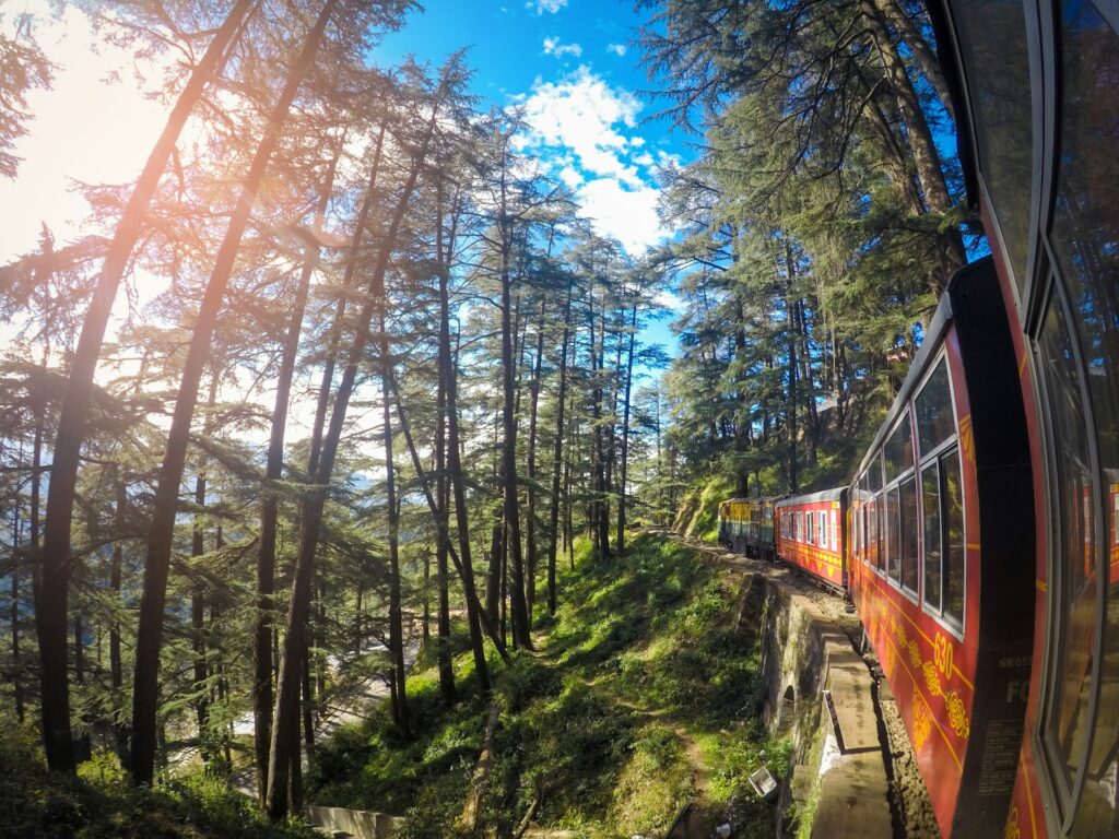 Toy train traveling through scenic hills on the way to Shimla in Himachal Pradesh
