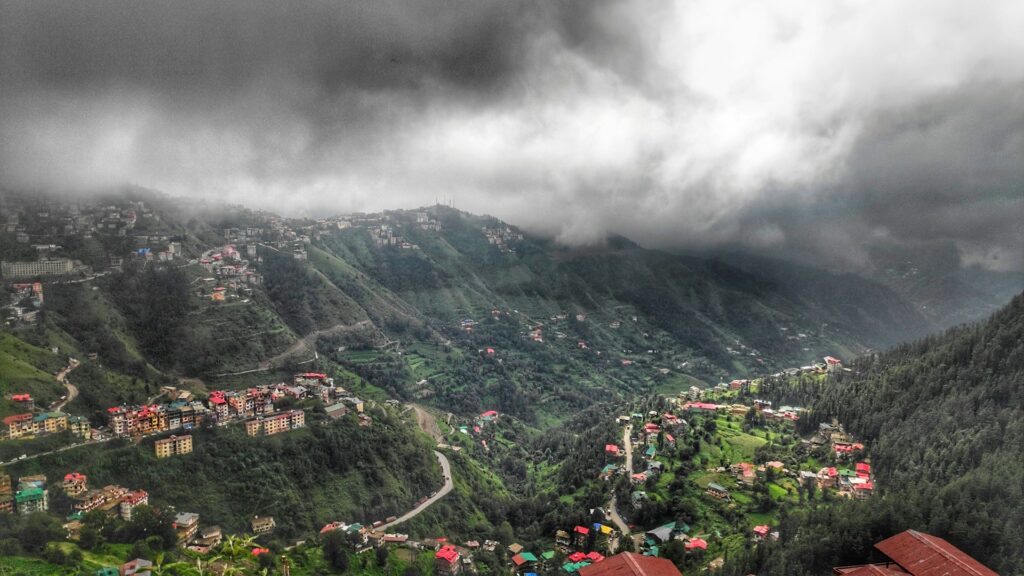 Panoramic view of Shimla Valley with hillside houses surrounded by lush green forests in Himachal Pradesh