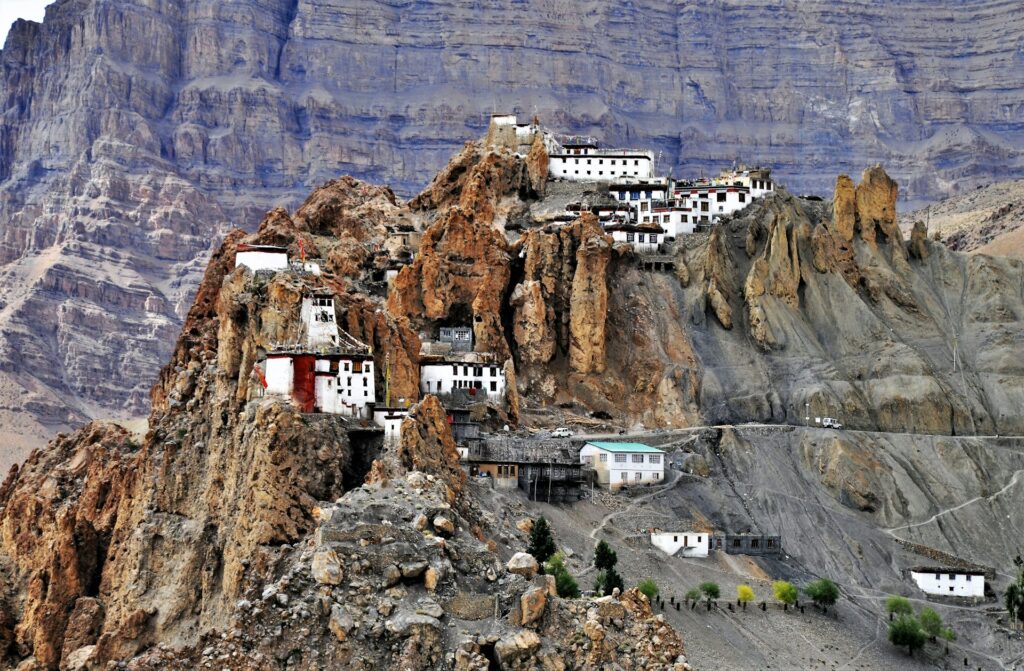 Remote village houses on rocky mountains in Spiti Valley under clear blue skies