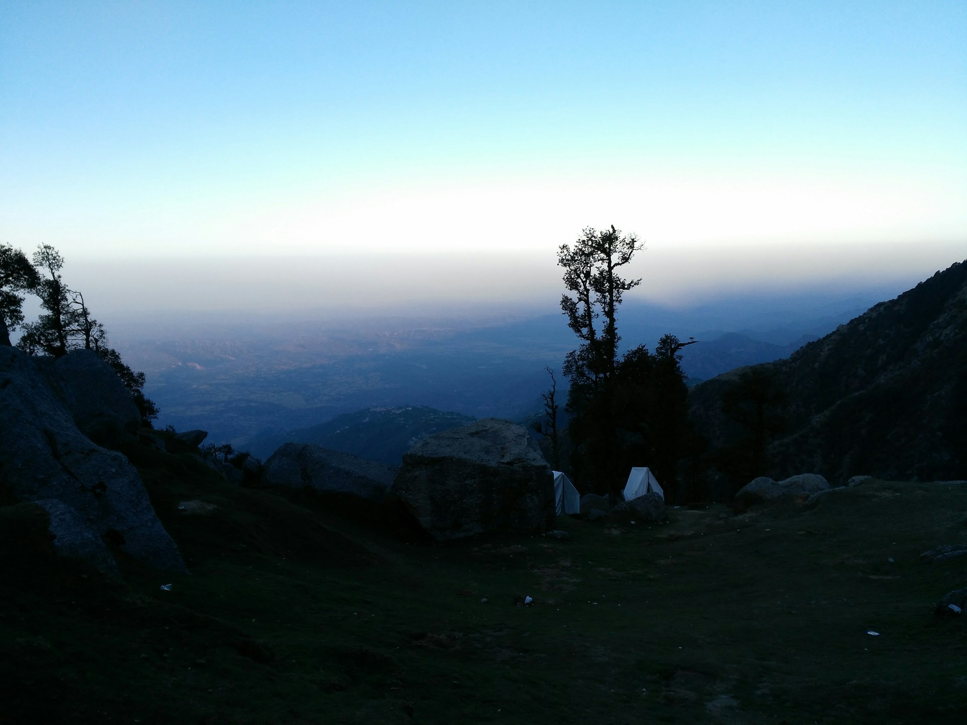 Golden sunset hues glowing over the vast Kangra Valley as seen from the top of Triund hill.