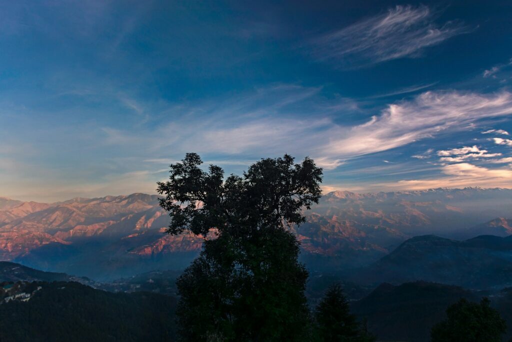 Snow-covered mountains glowing red under the golden sunrise in Dalhousie, Himachal Pradesh, offering breathtaking Himalayan views and unforgettable travel experiences with Visittaxi.com.
